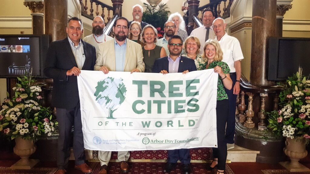 Tree Cities of the World banner being held by BTP, Councillors from BCC, and others in celebrations of Birmingham's recognition.