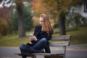 person on a bench in a park reading a book