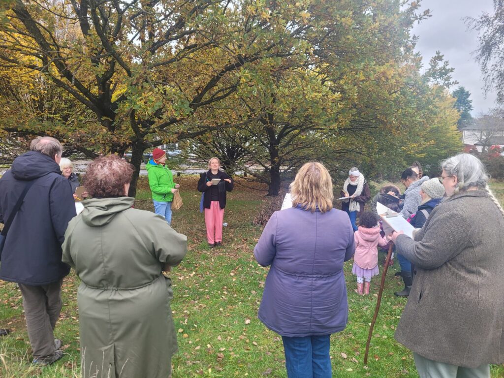 The group of walkers taking part in the hodge hill common tree walk, katy leading the group with a poem