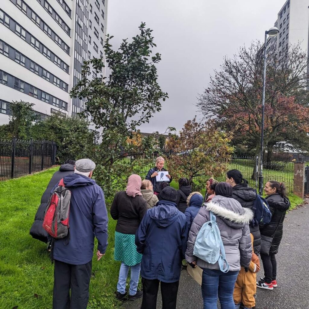 Katy on the Tree Walk surrounded by keen onlookers, identifying local trees in Nechells