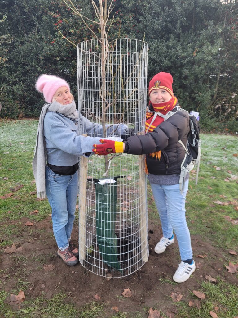 Katy and Lisa hugging the tree they worked so hard for - Hodge Hill tree planting for tree week 2023, UFA