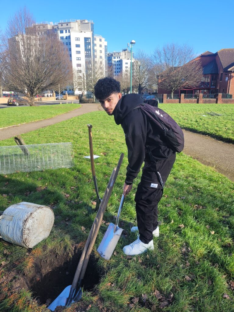 Krish Kumar helping to dig the tree pit for the iTree Eco tree planting commemoration.