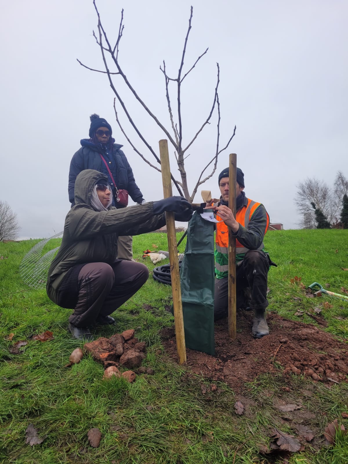 The Zephaniah Forest Family Legacy tree planting - Ebony, local resident, with Joyce and Matt doing the gator bag.